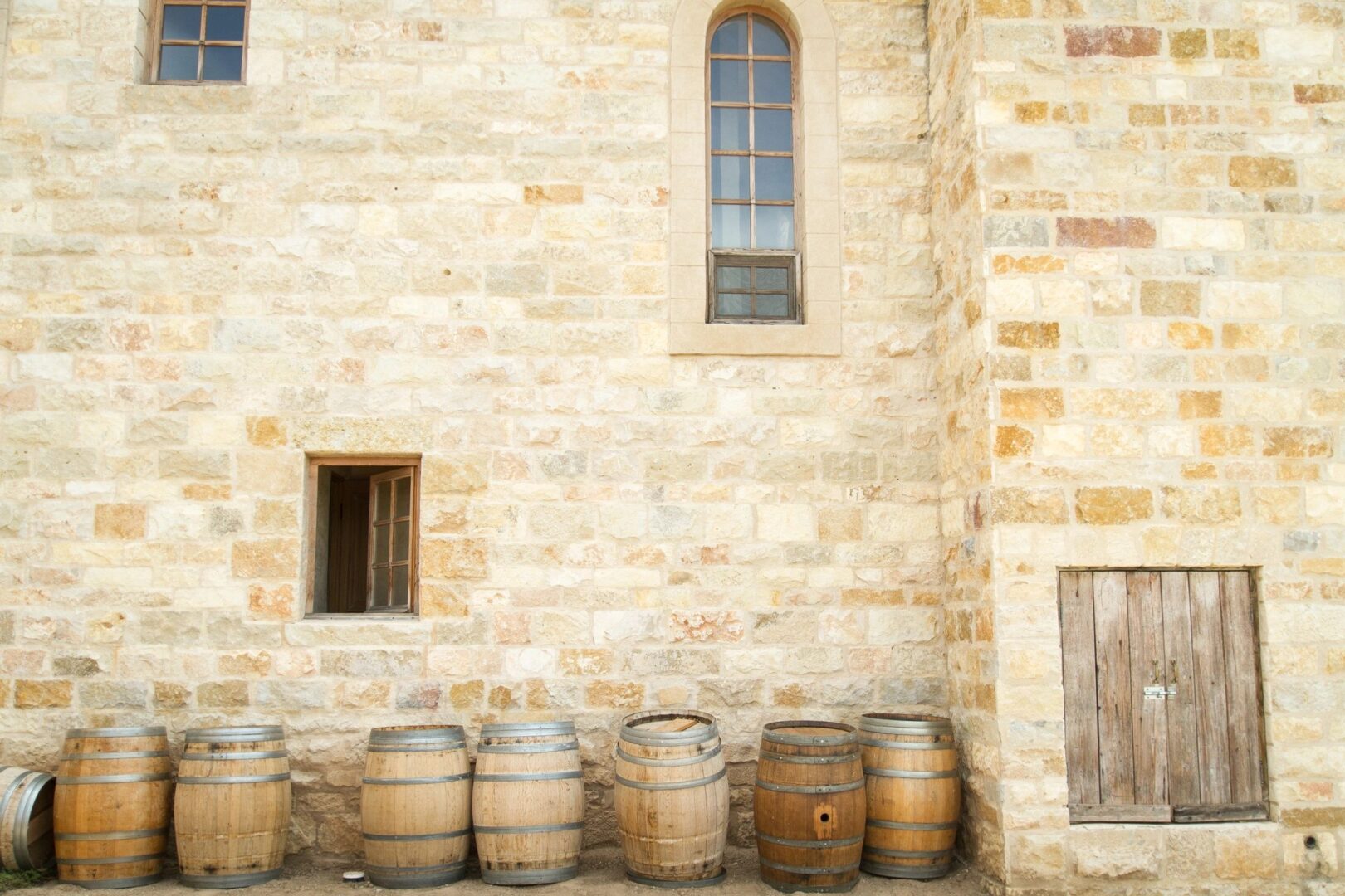 A bunch of barrels are lined up against the wall